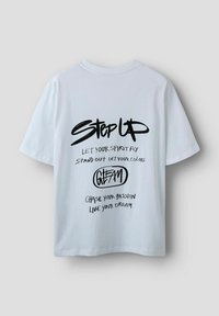 Hvid bomulds t-shirt med korte ærmer, der har sort håndskrevet tekst på ryggen: motiverende sætninger og et grafisk logo.