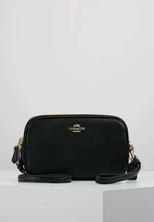 Sac en cuir noir à bandoulière avec finition texturée, quincaillerie dorée, fermeture éclair et bandoulière réglable. Forme rectangulaire compacte.