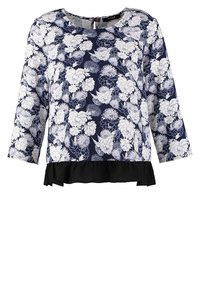 Blouse bleu marine avec motif floral blanc, manches trois-quarts, encolure ronde et ourlet volanté noir en bas.