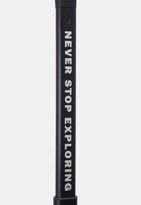 Crni aluminijski planinarski štap s mat finišom, s natpisom "NE PRESTAJ ISTRAGOVATI" u debelim bijelim slovima duž osovine.