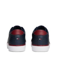 Marineblå lædersneakers med et bordeauxfarvet hælfill, hvid gummisål og et lille logodesign på bagsiden. Tekstureret overfladedesign.