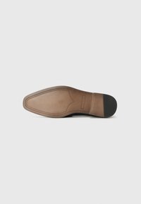 Semelle de chaussure en cuir marron avec une finition lisse, présentant une forme distincte et des détails de couture subtils. Semelle en caoutchouc noir offrant une traction au talon.