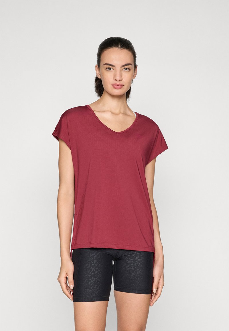 Bordeaux V-hals t-skjorte med korte ermer, kombinert med svarte teksturerte sykkelshorts. Stoffet ser glatt og elastisk ut.