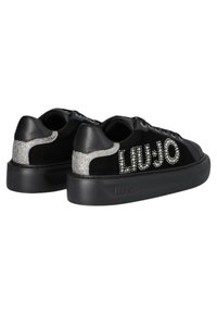 Sneaker nere con tomaia in suede e pelle, caratterizzate da dettagli glitterati e il nome del marchio 'LIU JO' in strass sul lato.