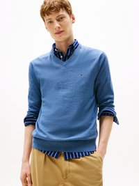 Modra v-neck pulover iz mehkega materiala, na belih in modrih črtah. Pulover ima rebraste manšete in pas, z majhnim logotipom na prsih.