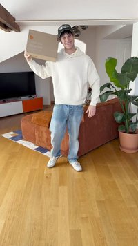 Kartonist kast koos tekstiga "Armsa mind. Kanna mind.", mida hoiab valges kampsunis ja siniste teksadega inimene heledas toas taimedega ja mööbliga.