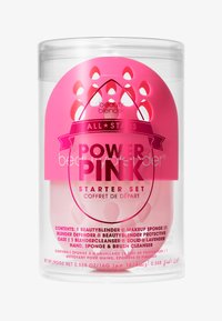 Zestaw startowy Beauty Blender Power Pink w przezroczystym plastikowym pojemniku. Zawiera jasnoróżowe akcenty, gąbkę oraz instrukcje dotyczące mydła do czyszczenia.