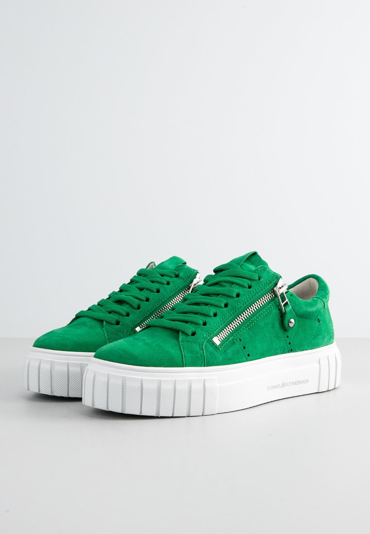 Grüne Wildledersneaker mit weißen Gummiplattformsohlen, ausgestattet mit funktionalen Reißverschlüssen und strukturierten Schnürsenkeln. Perforierte Details an den Seiten.