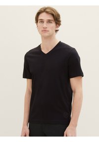 Tricou negru cu mânecă scurtă, cu un design în formă de V, fabricat dintr-un material neted, având un detaliu cu un logo mic pe tivul din stânga.