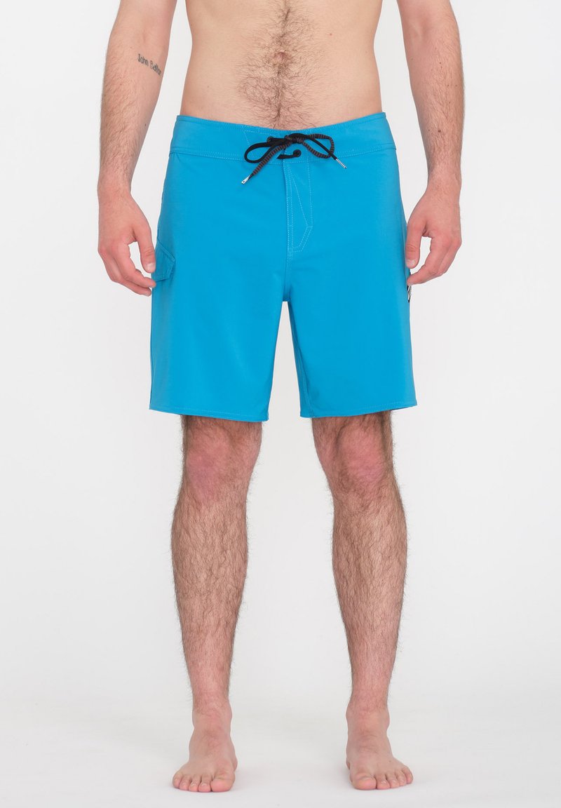 Blaue Badehose aus leichtem Material, mit einem elastischen Bund und Zugband sowie seitlichen Taschen. Glatte Textur und sauberer Schnitt.
