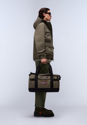 Olivgrüne Reisetasche aus Stoff mit schwarzen Akzenten, Griffen und einem norwegischen Flaggen-Patch. Weiches Material, zylindrische Form, mit Reißverschluss- und Schnallen-Details.