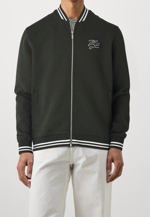 Svart bomberjacka med vita randiga ribbade ärmar och krage, dragkedjestängning och broderad logotypdetalj på bröstet.