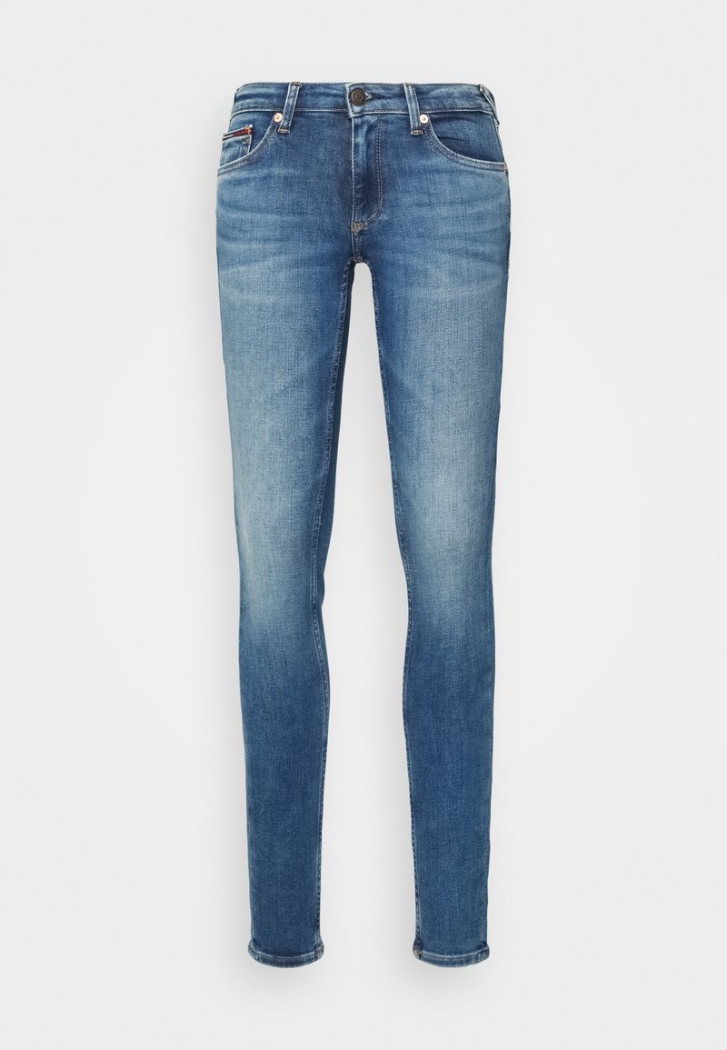 Kapeat farkut keskimäisessä sinisessä denimissä, joissa on klassinen viiden taskun muotoilu ja niittikoristeet, sekä hienovarainen haalistuminen ja sileä rakenne.