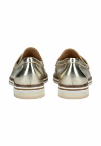 Scarpe metalliche dorate con tacco piatto, upper in pelle e accenti in contrasto di colore tan. Presentano una suola in gomma a strisce bianche e marroni.