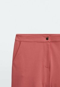 Stofkleurige broek in een stoffige roos kleur, met een gladde textuur, een platte tailleband, een kleine zwarte knop en zijzakken.