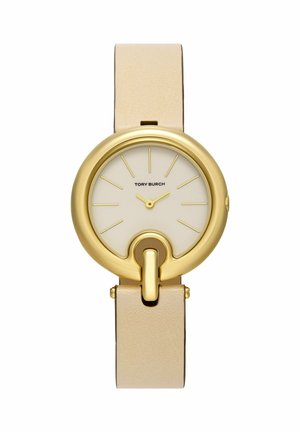 Montre ronde en or avec bracelet en cuir beige, cadran minimaliste avec index dorés et logo Tory Burch au centre.