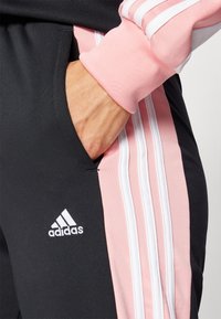 adidas Sportswear BOLDBLOCK TRACKSUIT - Tuta - black/semi pink spark