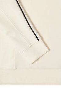 Licht beige sweatshirtmouw met geribbelde boord, met een zwarte streep langs de schouder. Gladde textuur, minimalistisch ontwerp.