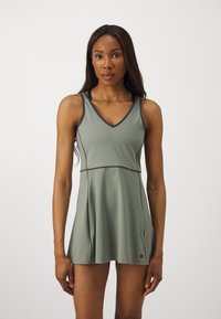 Vestido atlético verde com decote em V, design sem mangas e saia rodada. Feito de um material liso e elástico. Apresenta um acabamento contrastante.