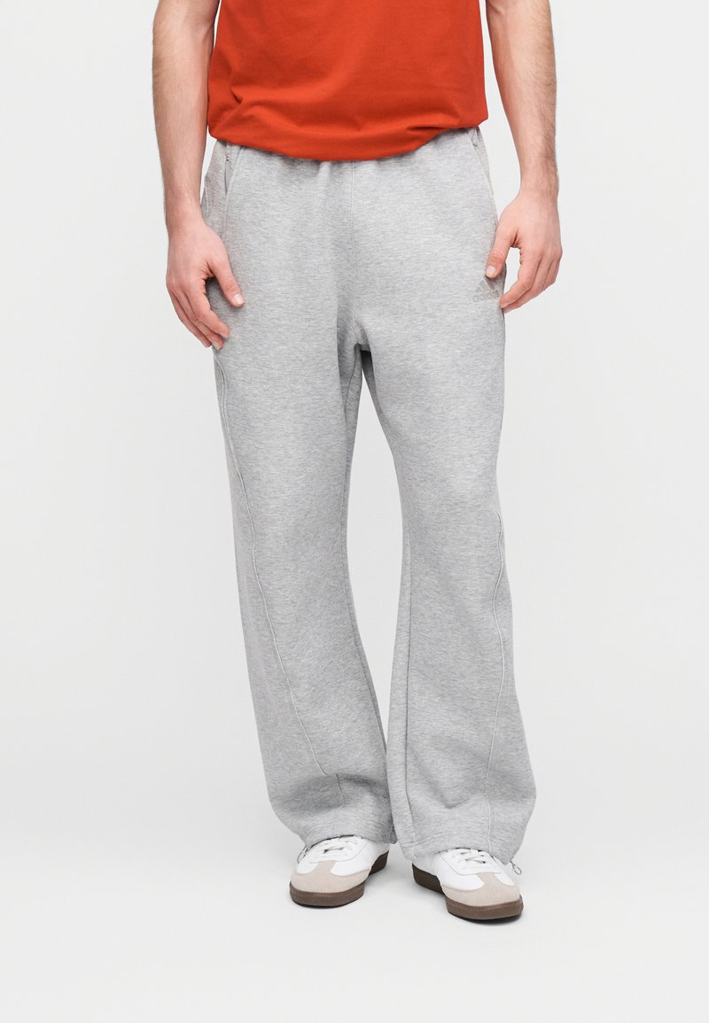 Pantalon de survêtement gris clair à coupe décontractée, en mélange de coton doux, doté de poches latérales et d'un marquage discret sur la jambe gauche.