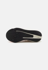 Suela de zapato con una superficie de goma negra texturizada, que presenta surcos y tres destacadas hendiduras circulares para tracción.