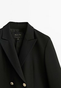 Blazer noir au design structuré, avec un col cranté, une fermeture à double boutonnage et des boutons dorés. Texture lisse, coupe ajustée.