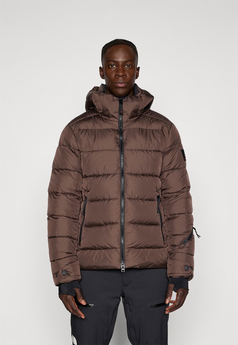 Braune Pufferjacke mit Kapuze, ausgestattet mit horizontalen Stepppanels, einem Frontreißverschluss und seitlichen Taschen. Hergestellt aus glänzendem, leichtem Material.