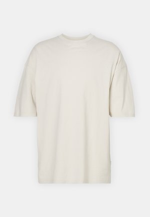 Majica s kratkimi rokavi in okroglim izrezom v odtenku off-white iz bombaža, ki se ponaša z udobnim krojem in mehkim teksturo, brez vidnih vzorcev ali dodatkov.
