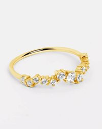 Goldfarbener Ring mit einer Reihe klarer Edelsteine, die in einem strukturierten Band mit variierenden Größen eingefasst sind, was einen abgestuften Effekt entlang der Oberseite erzeugt.