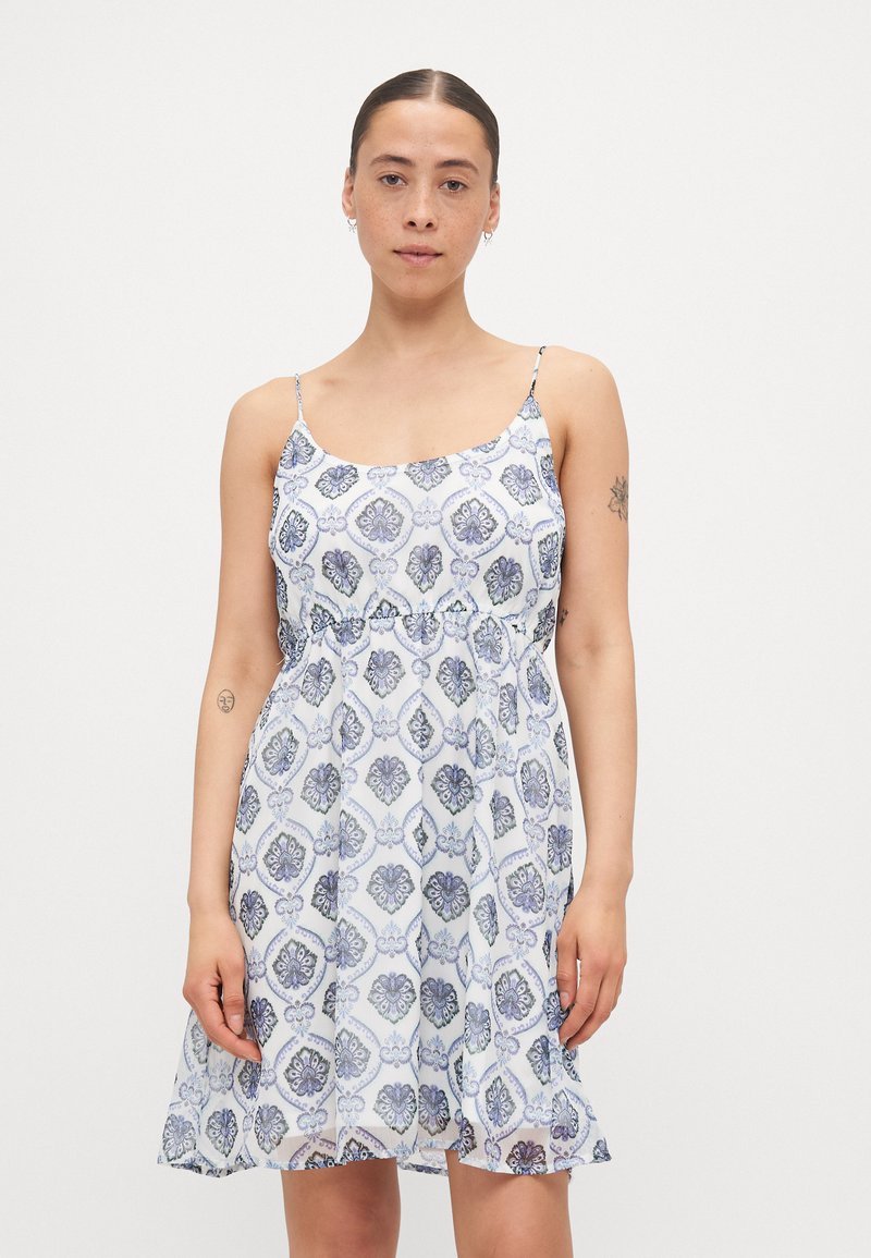 Rochie albă fără mâneci cu un design cu model albastru. Fabricată dintr-un material ușor, are fustă amplă și bretele subțiri ajustabile.