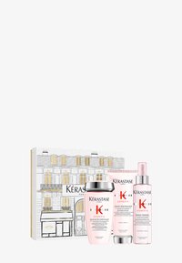 Il set regalo Kérastase Genesis include tre prodotti rosa: uno shampoo, un balsamo e uno spray per lo styling, il tutto in una confezione decorativa con un'illustrazione parigina.
