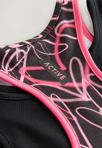 Sporttop mit schwarzer Basis und pinkfarbenen abstrakten Linien. Enthält ein Etikett mit dem Schriftzug "ACTIVE" in Weiß, umrahmt von einem pinkfarbenen Rand.