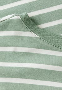 Tissu rayé vert et blanc avec un col rond. La texture est douce et lisse, avec des coutures soignées le long des bords.