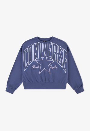 Lilla genser med stor hvit "CONVERSE"-tekst og en stjernegrafikk. Lange ermer, ribbestrikkede mansjetter og en tettsittende kant. Laget av bomullsblanding.