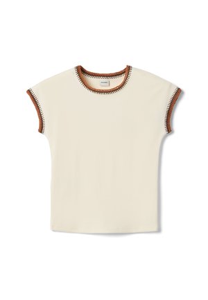 Top corto de manga corta en color crema con ribete de crochet en contraste marrón y negro en el escote y las mangas, visto desde arriba sobre fondo blanco.