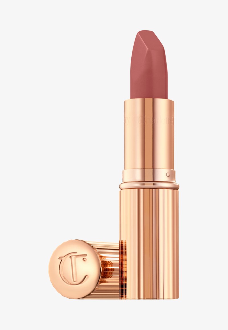 Rossetto opaco in rosa nudo con punta sfaccettata. Il caso color oro rosa presenta righe verticali e un emblema circolare alla base.