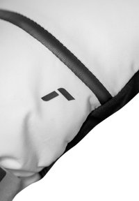 Vit och svart vadderad tyg med en svart rand och en liten logotyp. Slät textur med rundade kanter och inga ytterligare mönster.