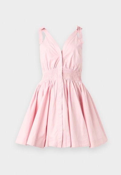 Φωτεινό ροζ φόρεμα χωρίς μανίκια με δεσίματα στους ώμους, κουμπιά μπροστά, σούρα στη μέση και φουσκωτή φούστα σε απλό φόντο.