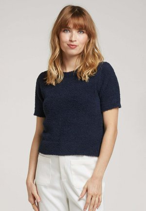 Top à manches courtes bleu marine en tissu texturé au toucher duveteux. Encolure ronde et coupe droite.