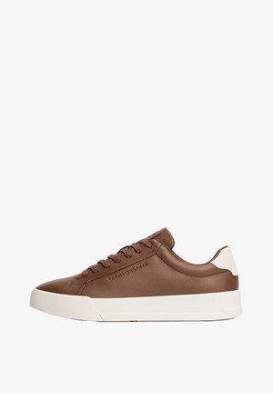 Sneaker marrone in pelle, modello low-top, con suola bianca e linguetta sul tallone, design con lacci e marchio in rilievo discreto sul lato.