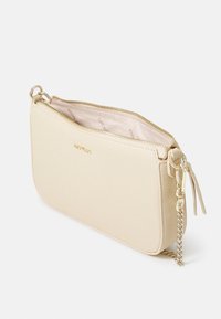 Beige leather crossbody bag with a textured exterior, gold-tone zipper, and chain strap. Interior features a light lining.