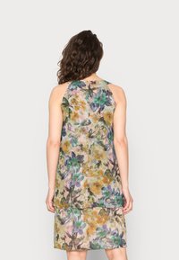Vestido sem mangas floral em tecido leve e transparente, com um padrão em aquarela em verdes, amarelos e roxos. Corte reto e sem forro.