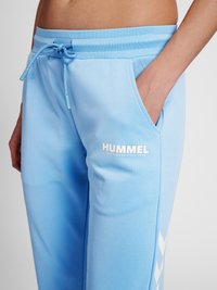 Ljusblåa sweatpants i mjukt tyg, med sidofickor, dragsko i midjan och vit Hummel-logotyp med mönstrade detaljer.