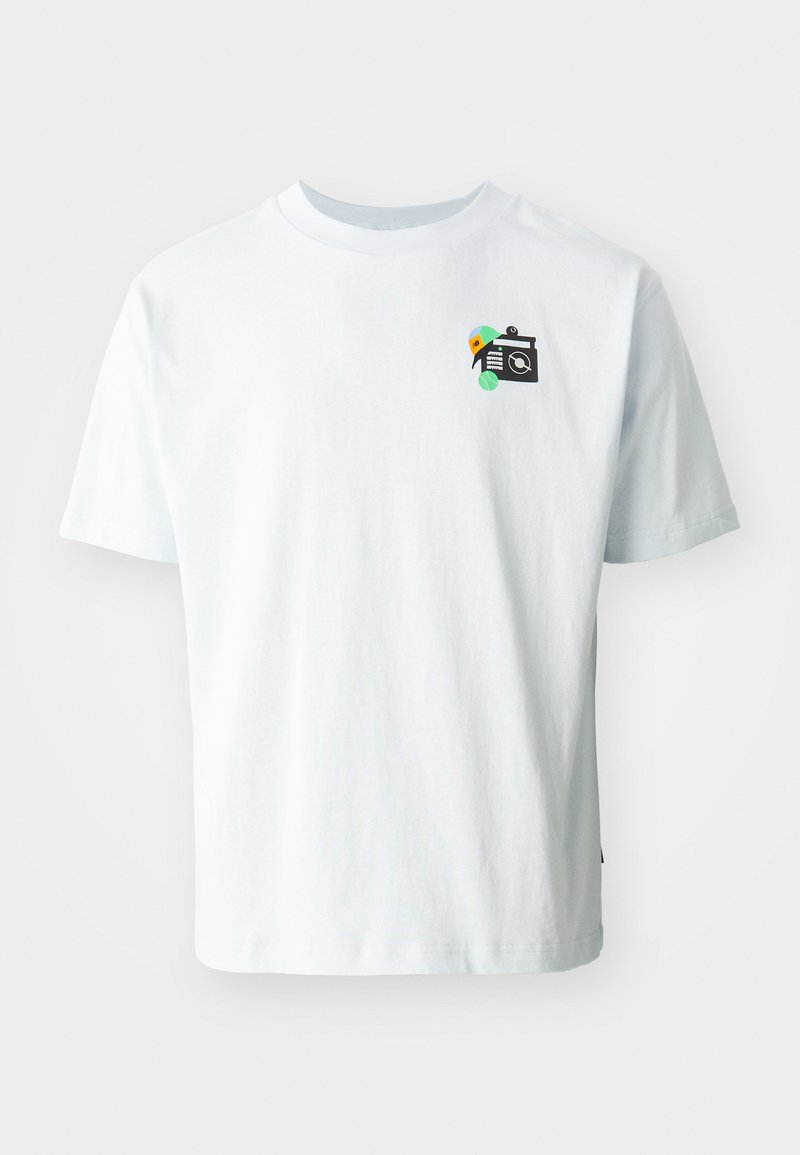 Camiseta de algodón en azul claro con escote redondo. Presenta un pequeño gráfico de una cámara con acentos de colores en el lado izquierdo del pecho.