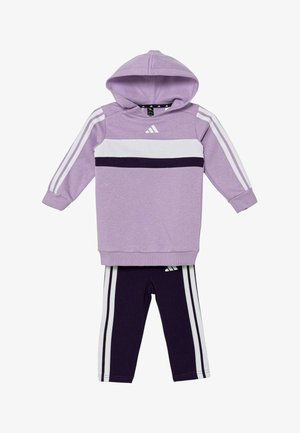 Sudadera con capucha morada con rayas blancas y morado oscuro, con capucha y puños acanalados. Leggings morado oscuro con rayas blancas a los lados.