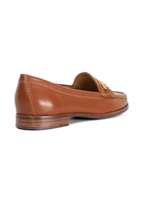 Tan leather loafer with a rounded toe, golden hardware detail, small stacked heel, and intricate stitching along the edges.