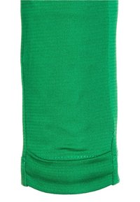 Groene katoenen stof met een gladde textuur. Bevat een zoom aan de onderkant en een subtiel verticale breipatroon. Geen extra details zichtbaar.