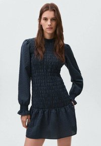 Mornarsko modra mini obleka z nabrano telovnikom in dolgimi napihnjenimi rokavi, ki ima večplastni ruffled rob ter karo vzorec po vsej obleki.