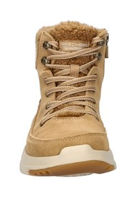 Bota impermeable marrón con un suave collar de forro polar, cierre de cordones y parte superior de ante texturizado. Cuenta con una suela de goma para agarre y durabilidad.