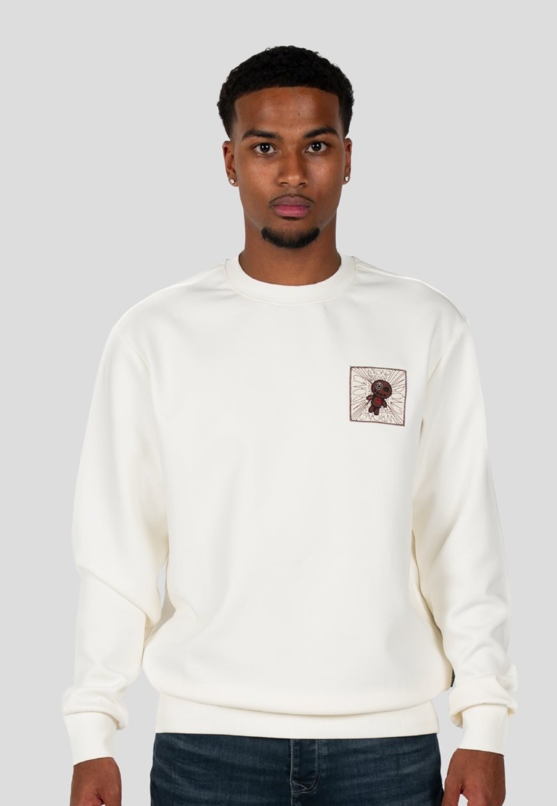 Felpa bianca con maniche lunghe, caratterizzata da un collo tondo e un'etichetta ricamata quadrata sul petto con un dettaglio grafico.